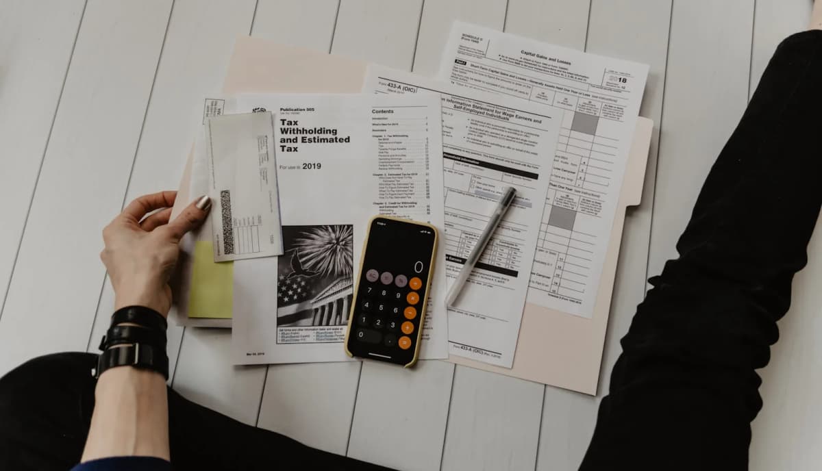 A calculator and pen on a monthly budget worksheet